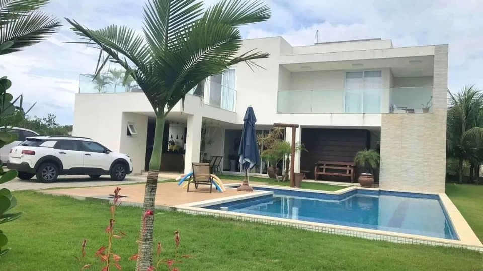 Casa moderna com piscina e jardim verdejante.
