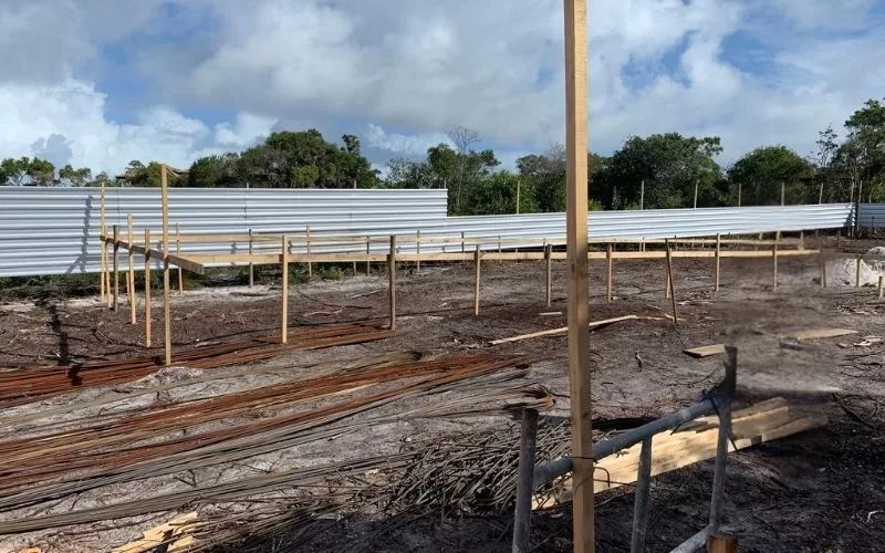 Pátio de construção cercado por madeira e metal.