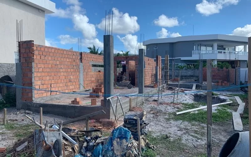 Construção de casa em andamento, tijolos e pilares.