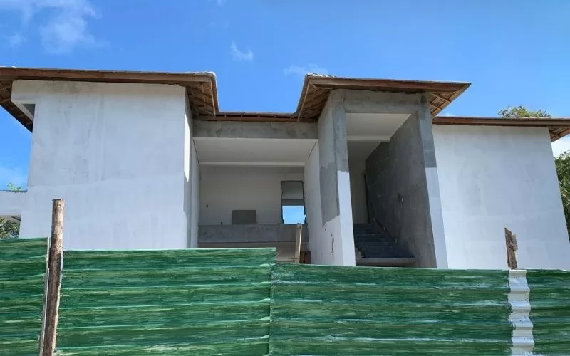 Casa em construção com paredes brancas.