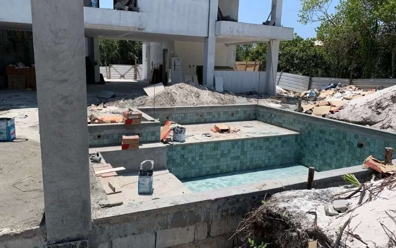 Construção de piscina em andamento numa casa moderna.