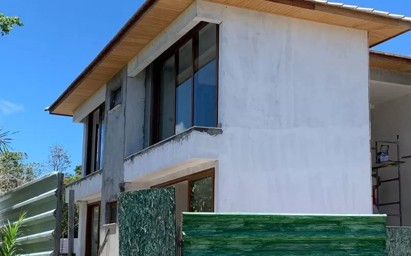 Casa moderna em construção com janelas grandes.