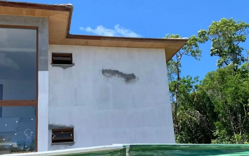 Casa moderna com parede branca e janelas pequenas.
