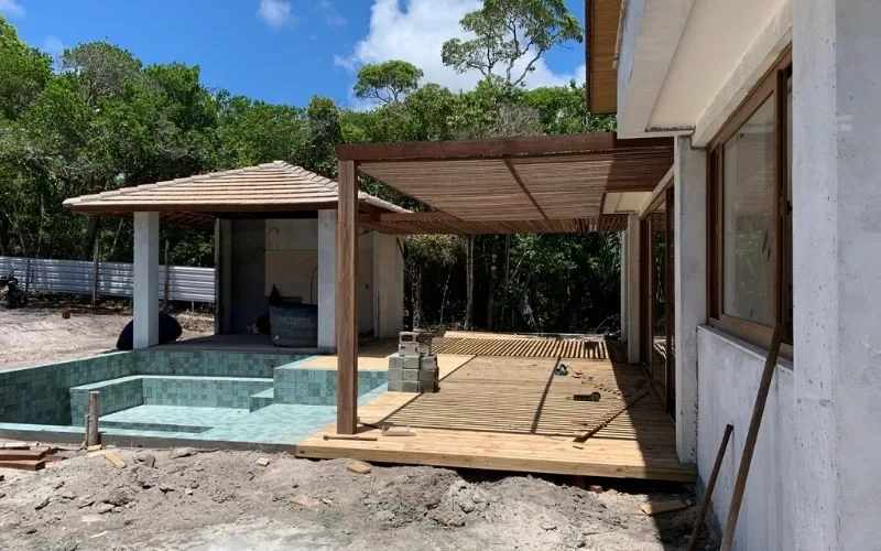 Construção de piscina e deck em jardim tropical.