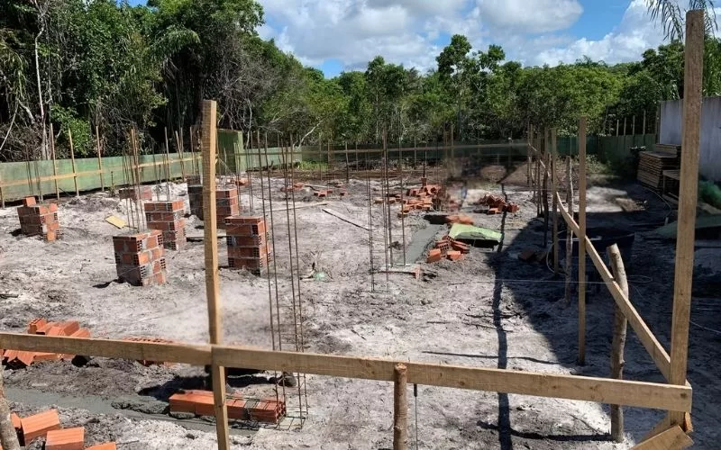 Construção de fundações com tijolos e estrutura de madeira.