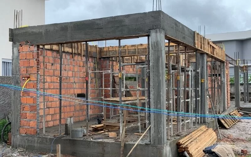 Construção de casa com estrutura de tijolos e concreto.