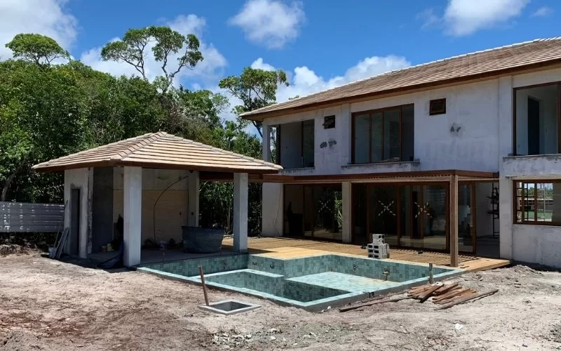 Casa em construção com piscina inacabada