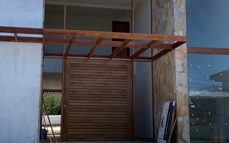 Entrada moderna com madeira e pedra.