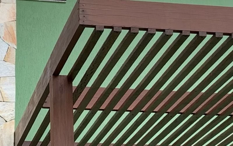 Estrutura de madeira contra parede verde.