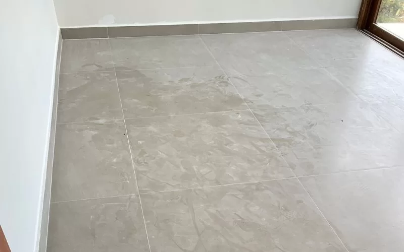 Piso de cerâmica bege em sala vazia.