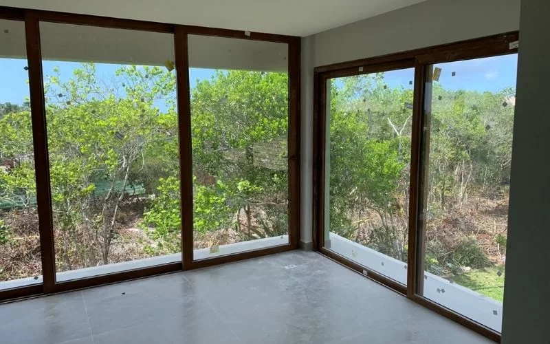 Sala com janelas amplas e vista para jardim.