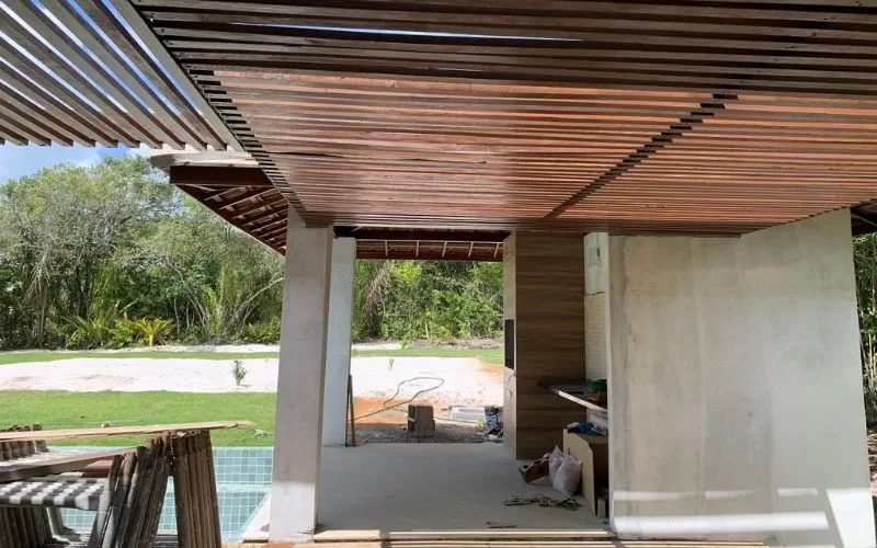 Construção moderna com telhado de madeira e jardim.