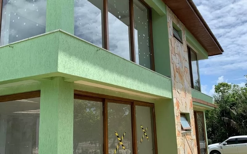 Casa verde com grandes janelas de vidro