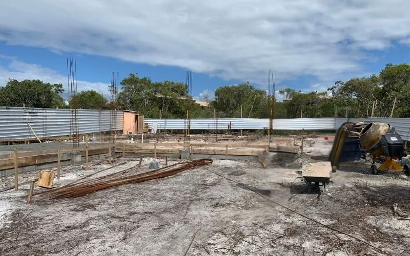 Terreno de construção com materiais e betoneira.
