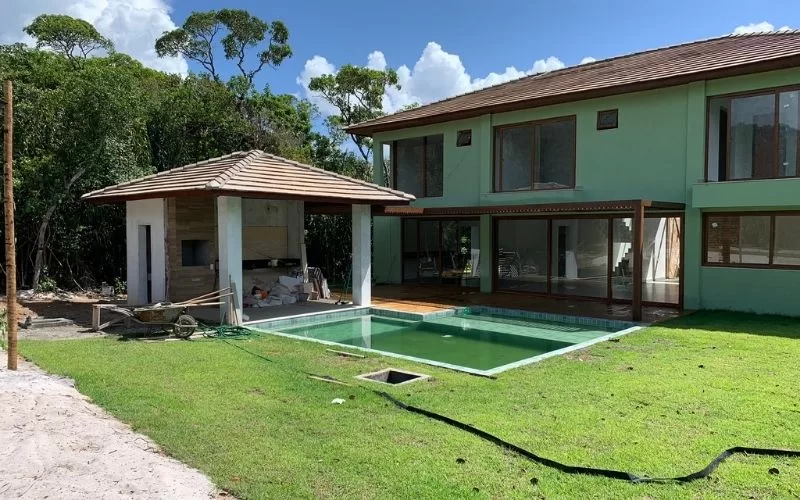 Casa moderna com piscina e jardim verde.