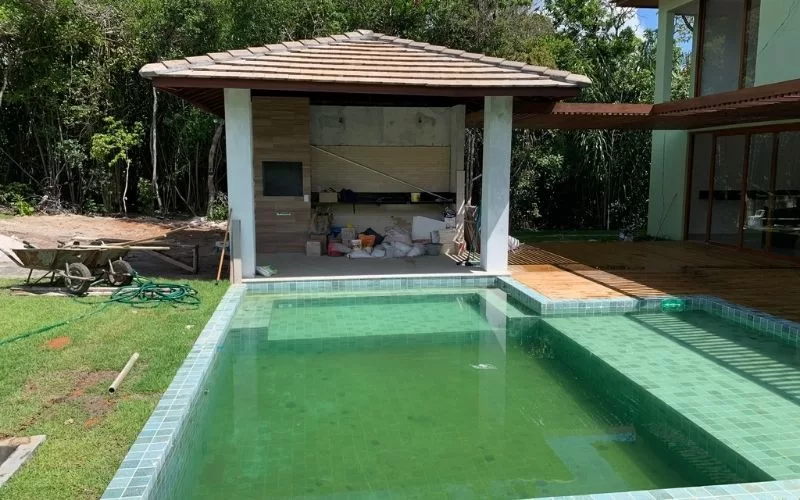 Área de piscina inacabada com estrutura de descanso.