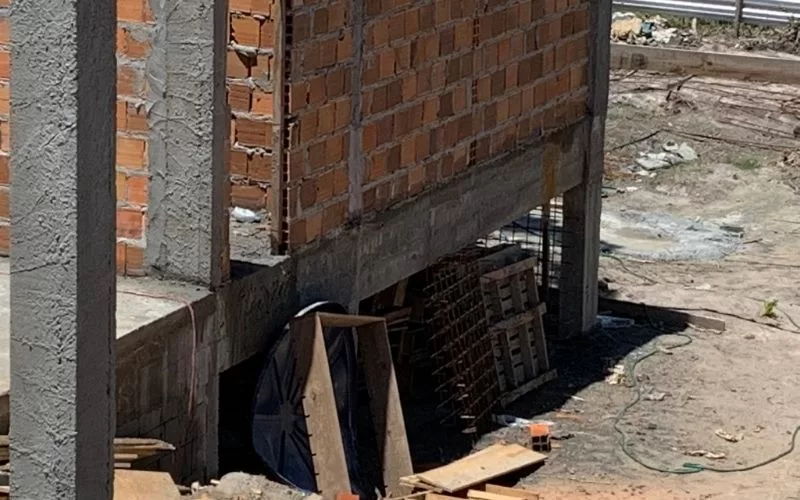 Parede em construção com tijolos expostos.