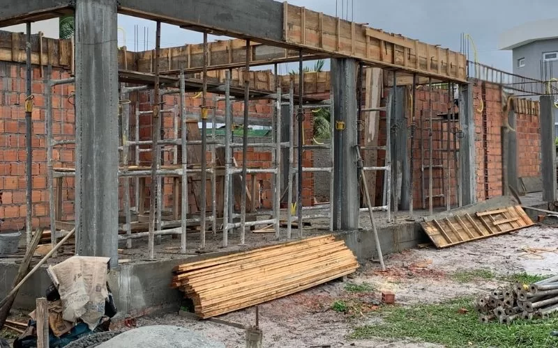 Construção de casa em fase inicial, tijolos visíveis.