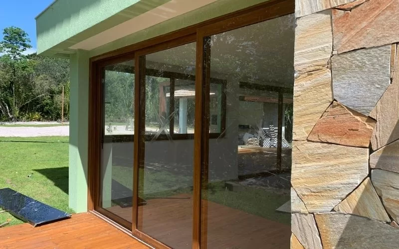 Casa moderna com paredes de vidro e pedra.