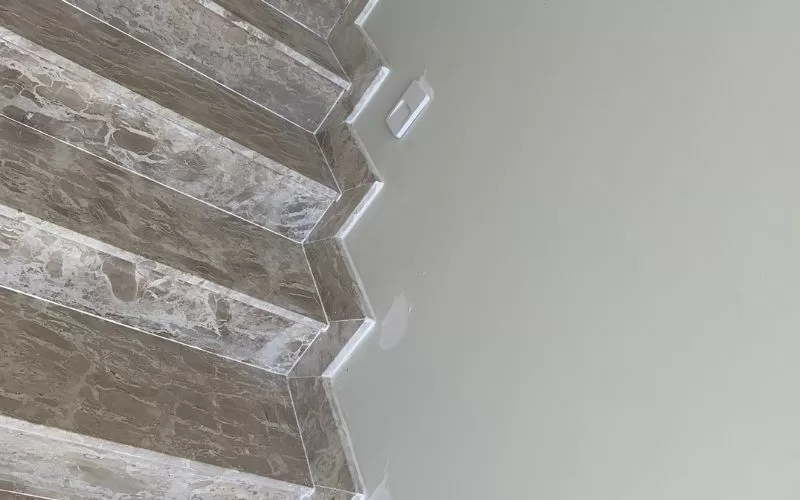 Escadas de mármore com parede de cor clara.