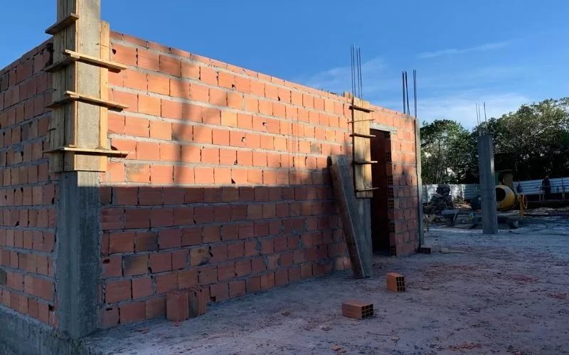 Construção de parede com tijolos e estrutura base.