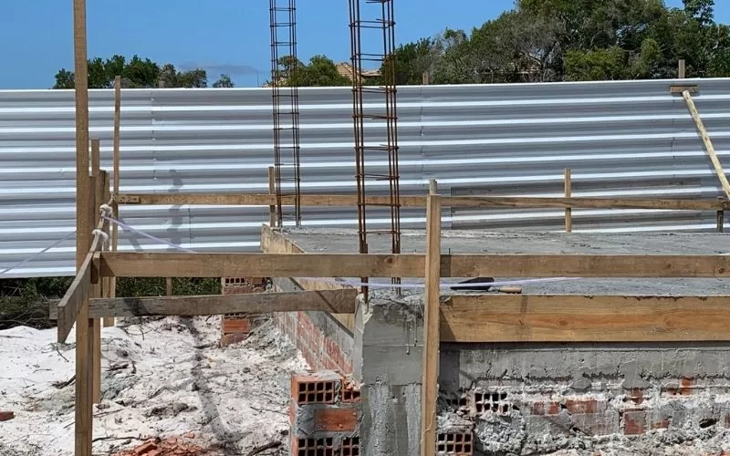 Construção com pilares, andaimes e cercas de madeira.