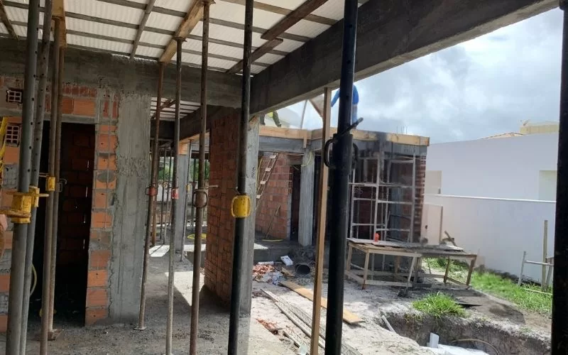 Obra em construção com paredes de tijolo expostas.