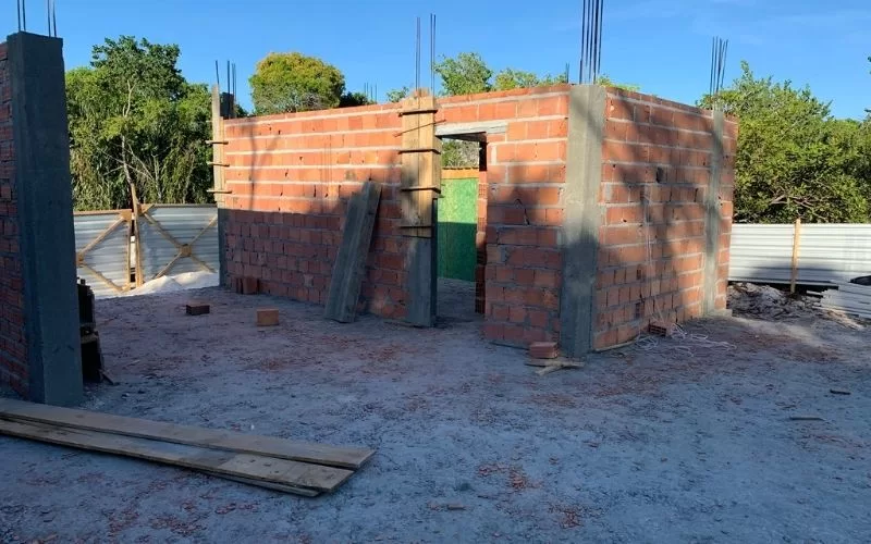 Construção de casa pequena com tijolos vermelhos.