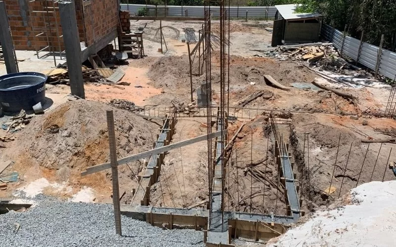 Terreno em construção com fundações expostas.