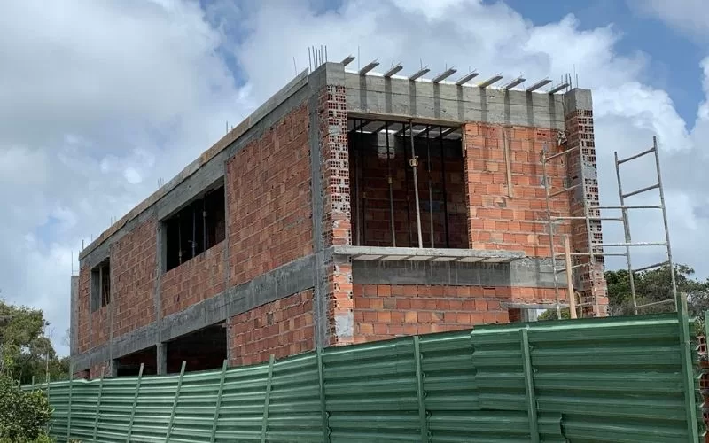 Construção de casa em alvenaria com tijolos expostos.