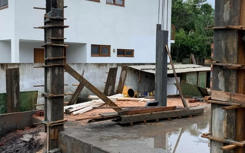 Construção residencial inacabada com materiais no local.