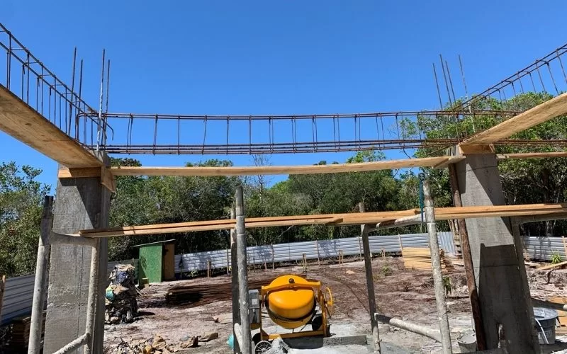 Construção civil em progresso com betoneira e estrutura.