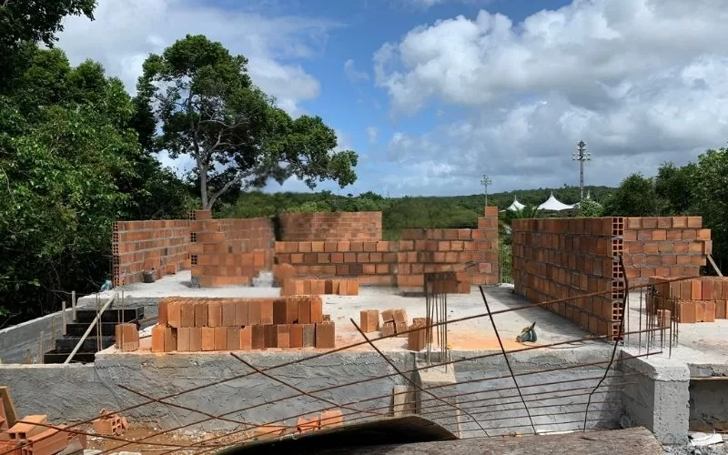 Construção de casa com tijolos e alvenaria em progresso.