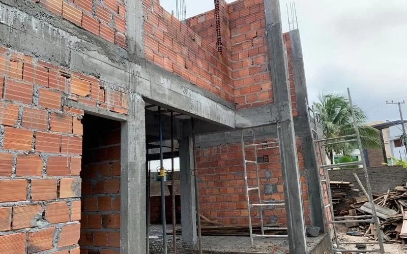 Construção de casa inacabada com tijolos expostos.