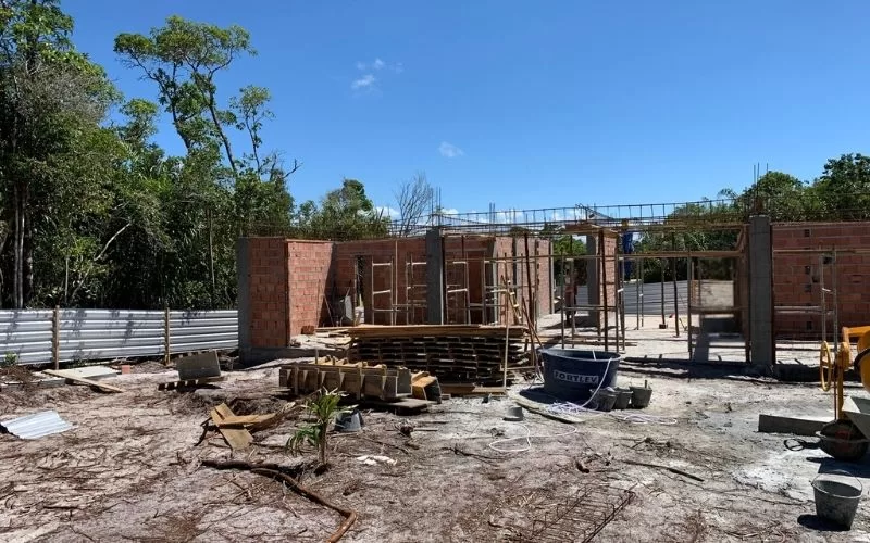 Construção em progresso com tijolos e ferramentas.