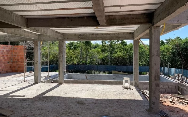 Estrutura de construção de casa com piscina inacabada.