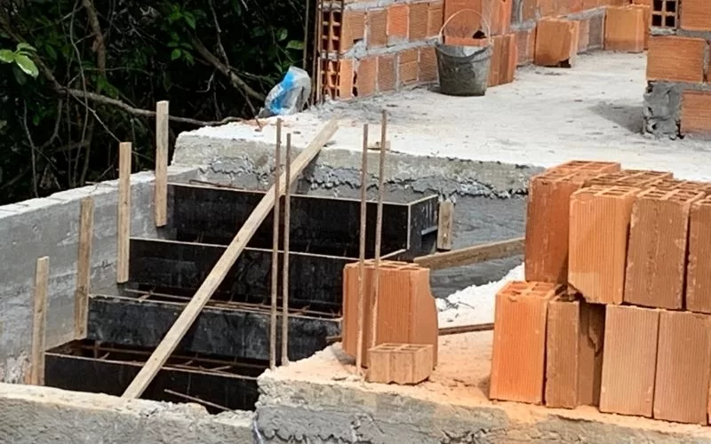 Construção de escadaria com tijolos e cimento.