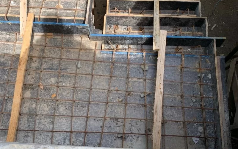 Laje de betão armado em construção, com moldura de madeira.
