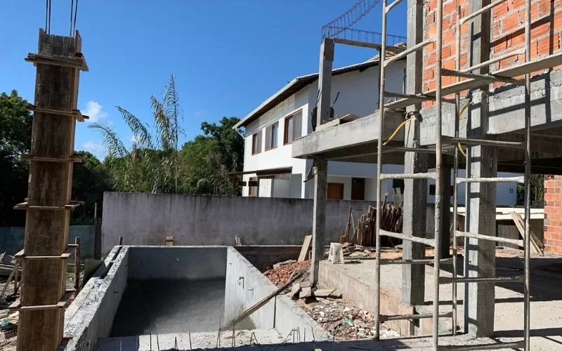 Construção residencial em andamento com piscina vazia.