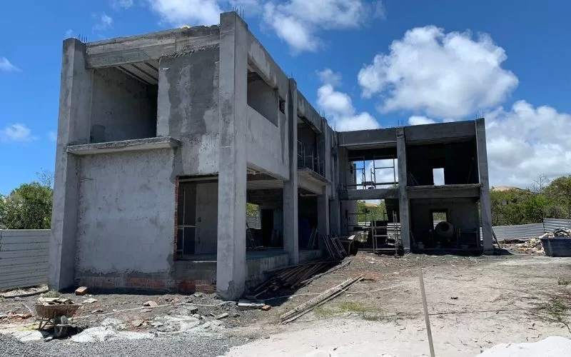 Construção de edifício inacabado sob céu azul em Portugal.