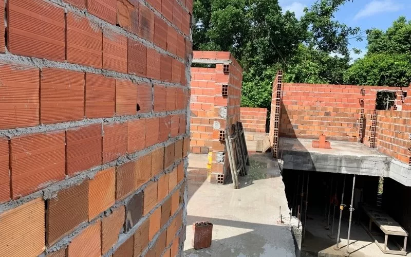 Construção de parede em tijolos num edifício inacabado.