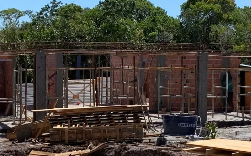 Construção de casa em andamento com tijolos à vista.