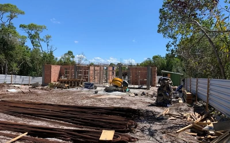 Construção em andamento com materiais no local.