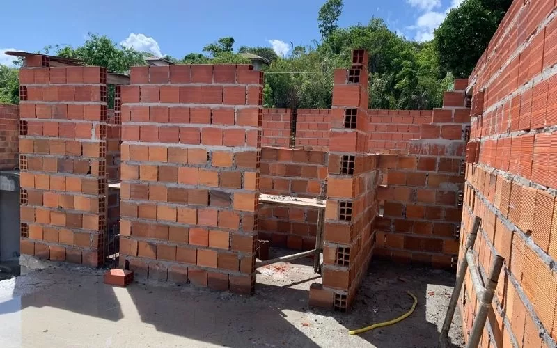 Construção de paredes com tijolos em andamento.
