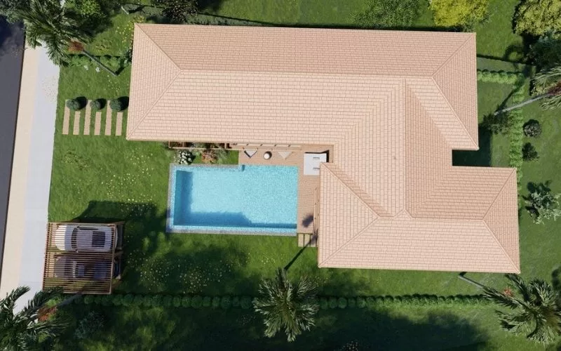 Vista aérea de casa com piscina em jardim verde.