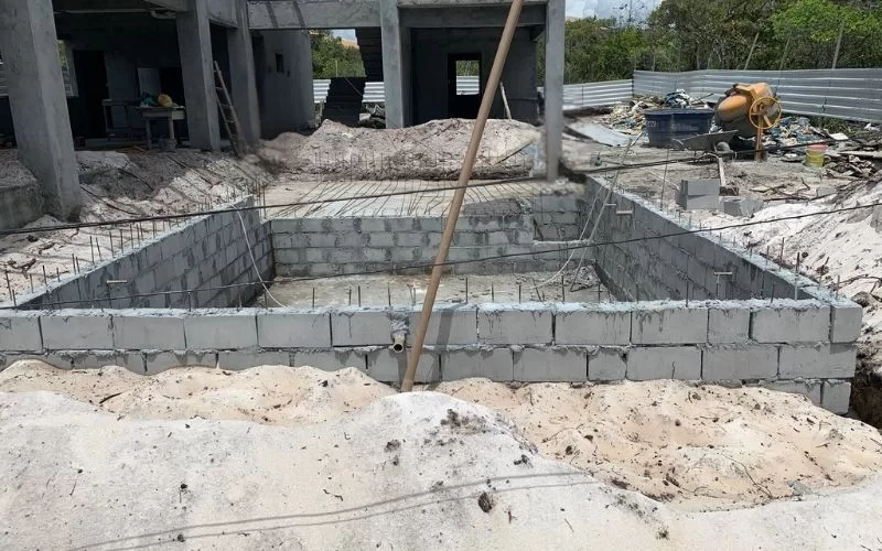 Construção de piscina em fase inicial, obra em andamento.