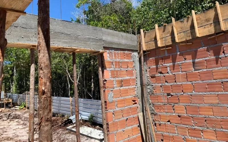 Construção de parede de tijolos vermelhos em progresso.