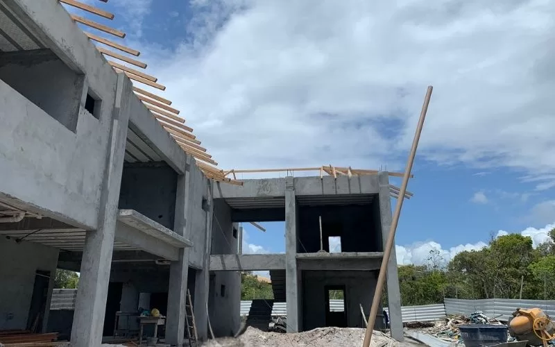 Construção de edifício em andamento, céu parcialmente nublado.
