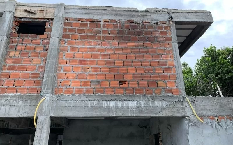 Construção de parede de tijolos inacabada ao ar livre.
