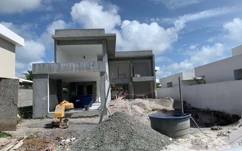 Casa moderna em construção sob céu azul.